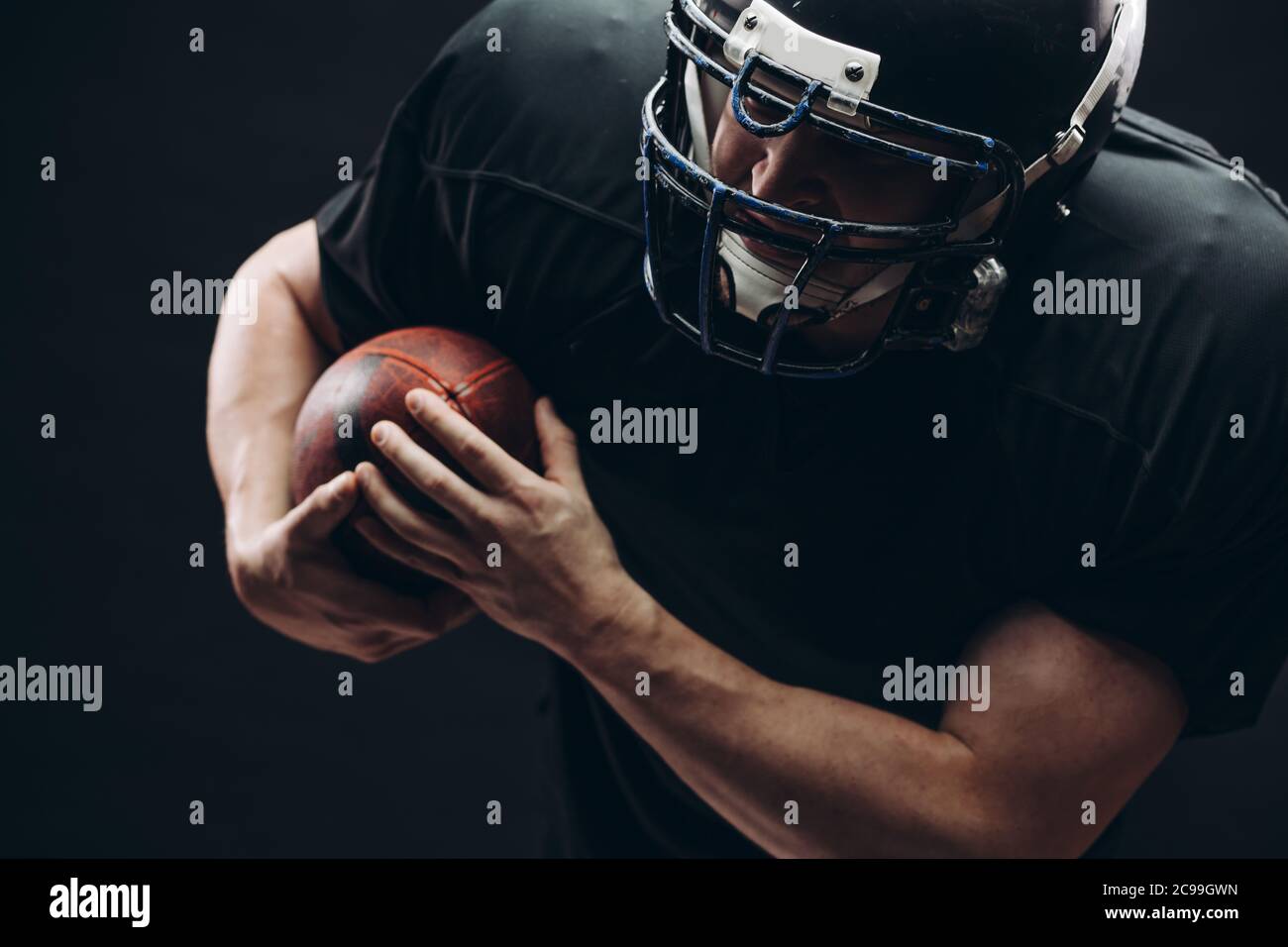 American football player with helmet and armour passing a ball while