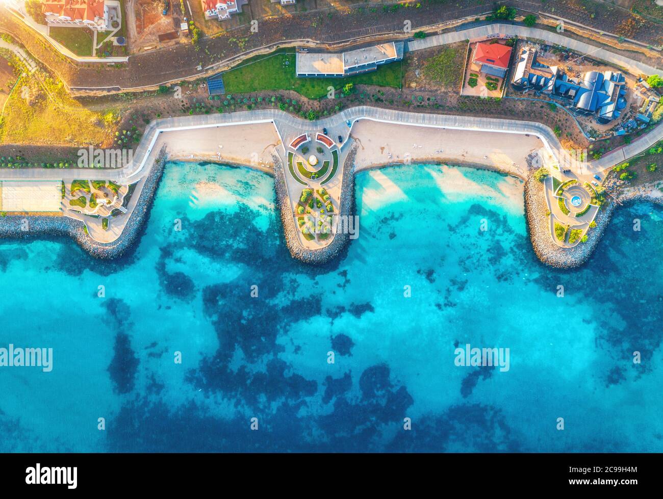 Aerial view of sandy beach, blue sea, restaurants at sunset Stock Photo