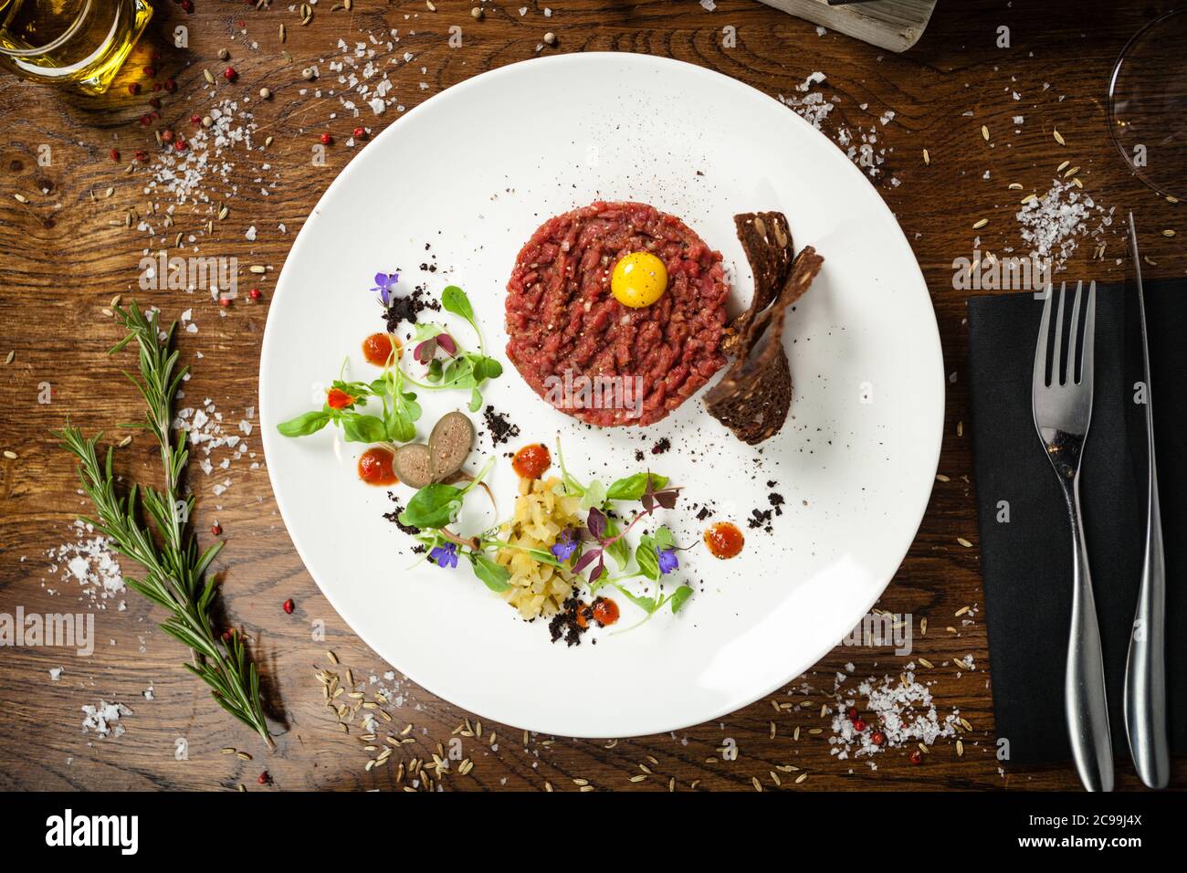 Steak tartare. Horseradish creme, black bread, baguette chips on white plate. Delicious healthy raw meat food closeup served on a table for lunch in Stock Photo