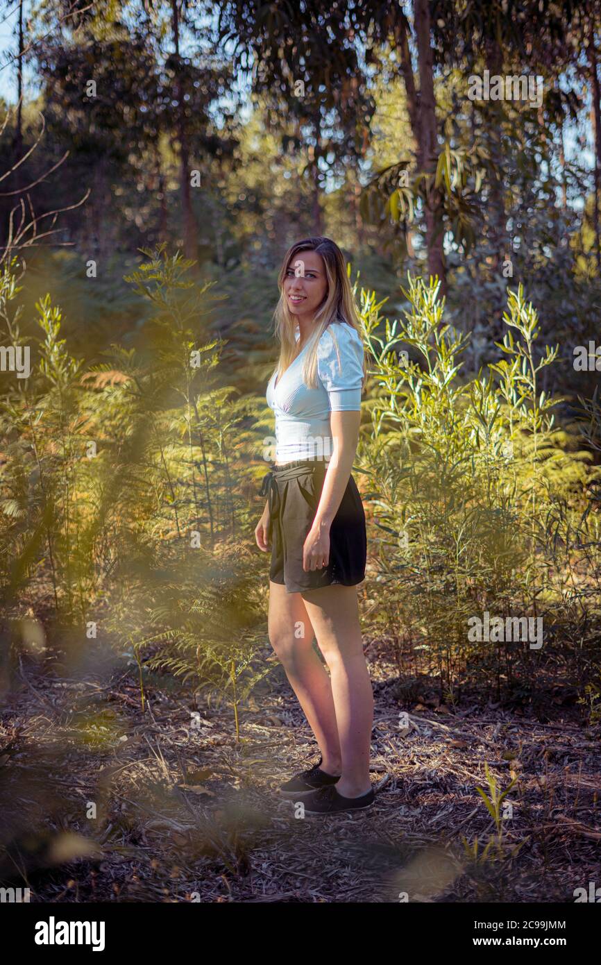 Young woman standing in the middle of the forest Stock Photo - Alamy