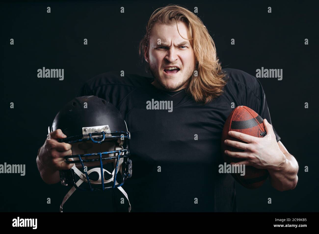 Angry american football coach holding football ball over isolated