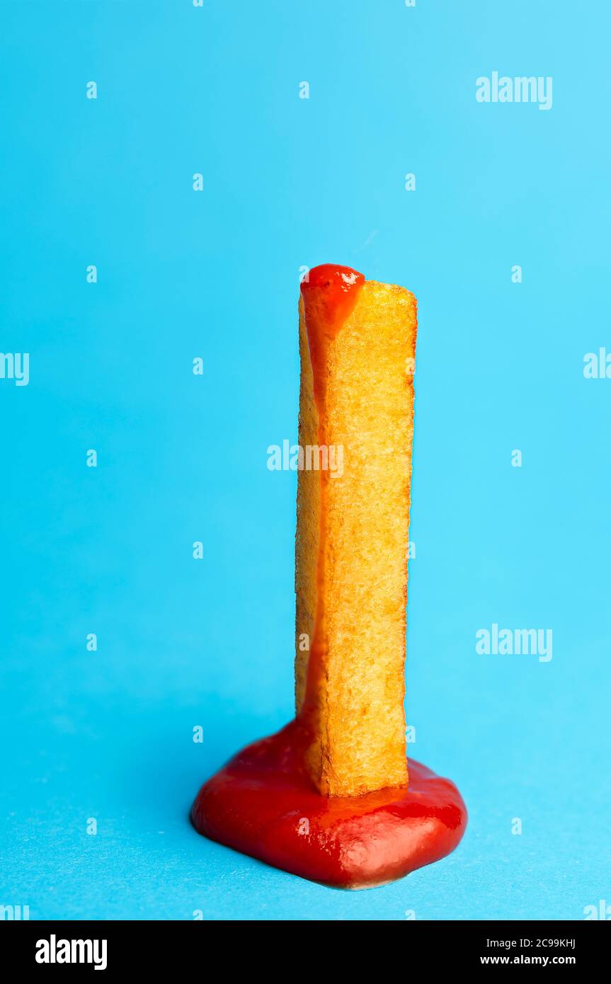 French Fries With Ketchup One Piece Isolated On Blue Seamless Background Close Up With A Single Potato French Fried In Tomato Sauce Fast Food Stock Photo Alamy