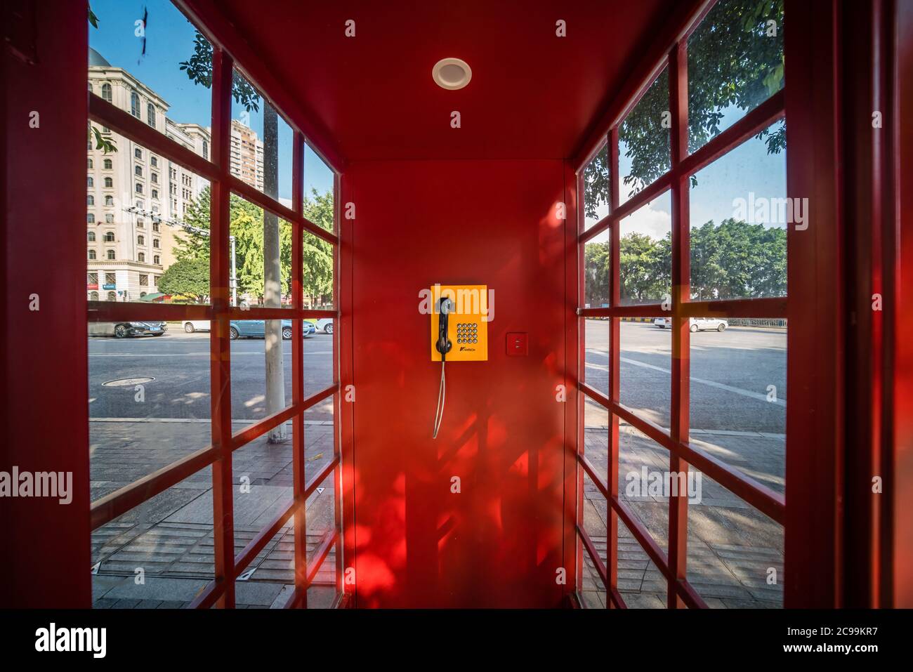 Chongqing, China -  August 2019 : Public phone inside the red telephone booth Stock Photo