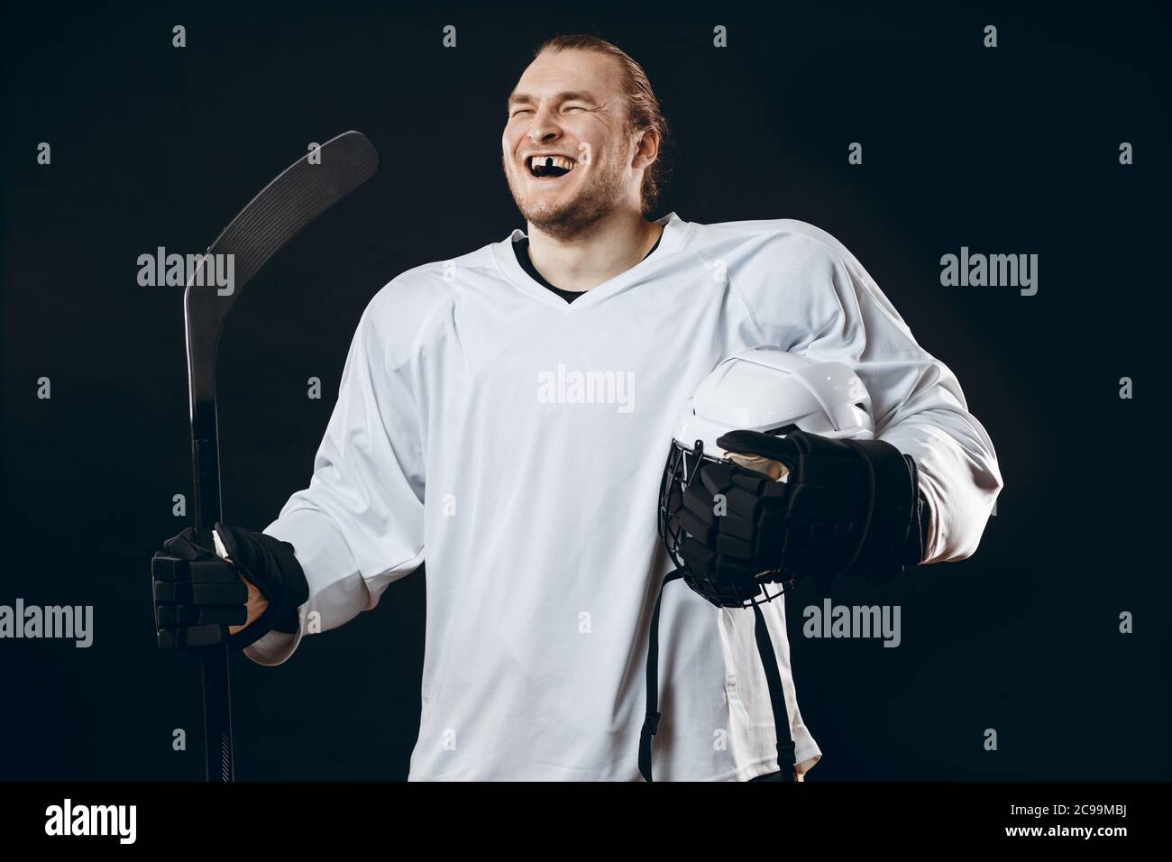 Happy Handsome hockey player with one broken front tooth laughing at