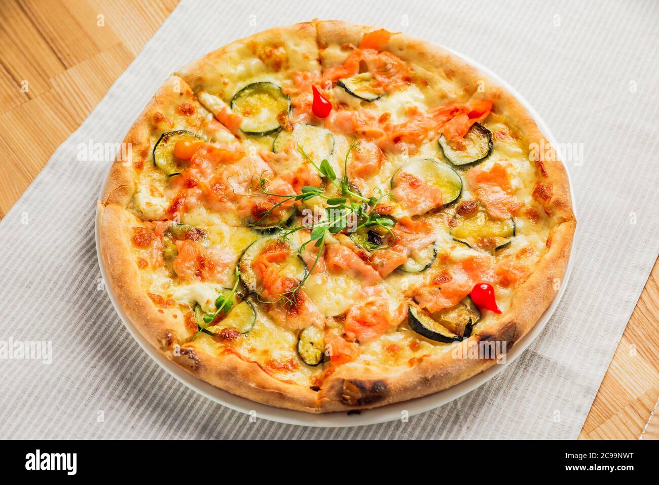 Pizza with zucchini, red fish and cheese, on a white plate Stock Photo -  Alamy