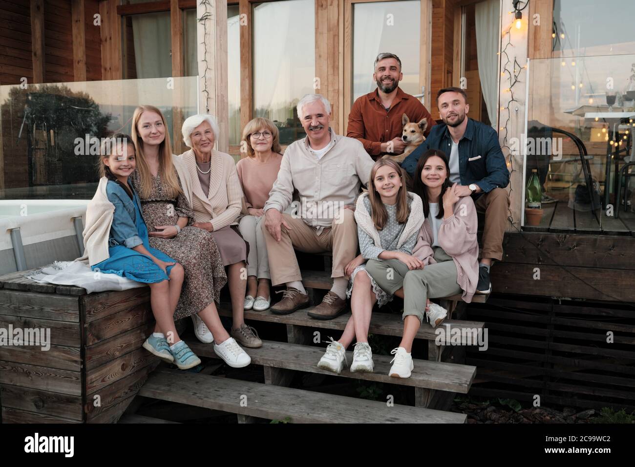 Portrait of big happy family sitting on the porch and smiling at camera