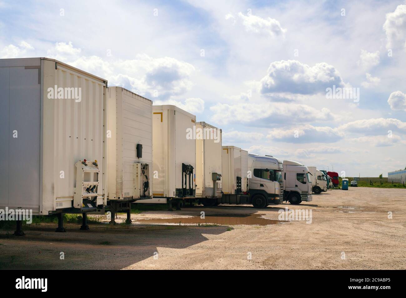 Various types of vehicles waiting to be unloaded and loaded. Maneuvering area for trucks. Stock Photo