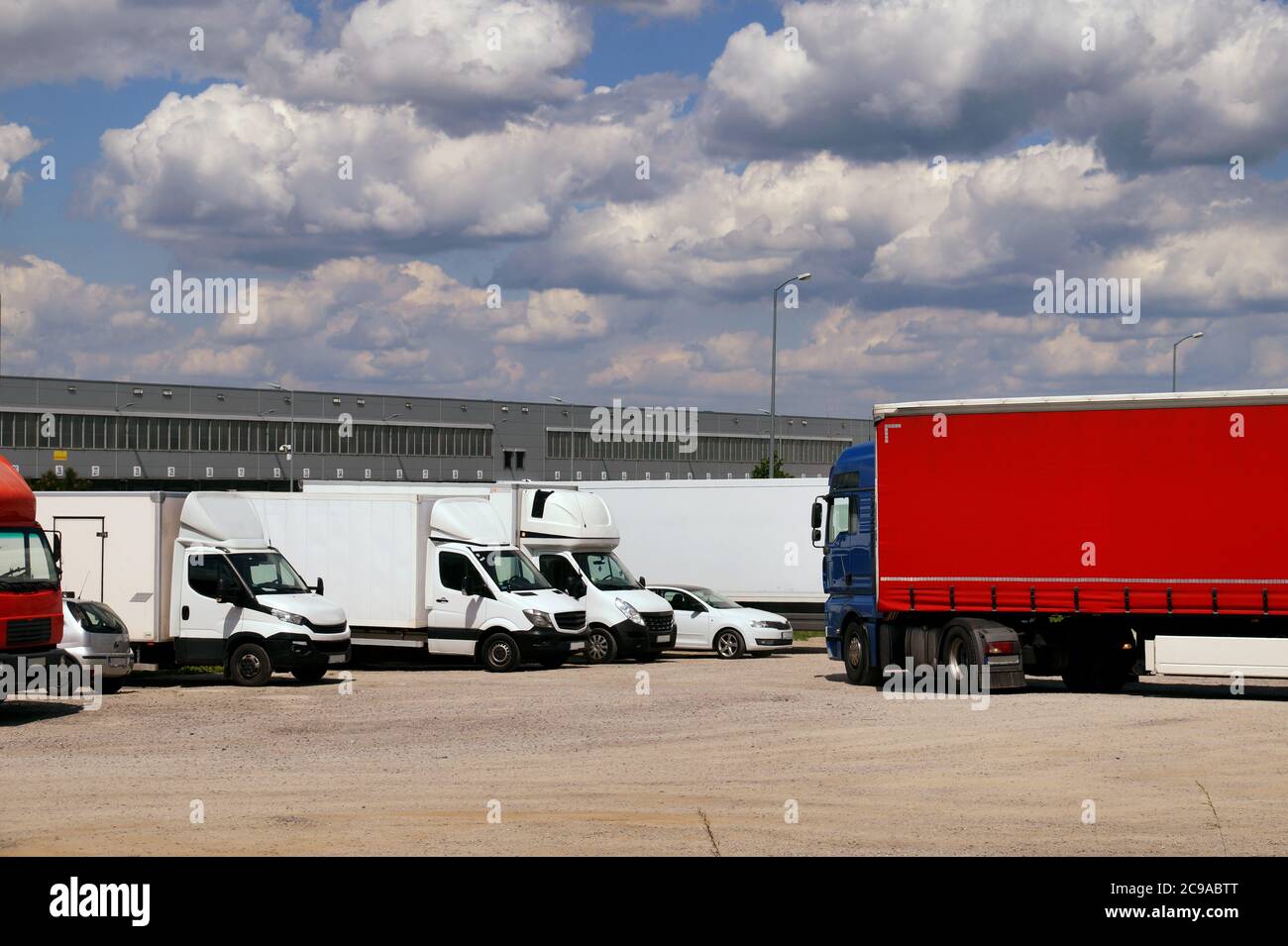 Various types of vehicles waiting to be unloaded and loaded. Maneuvering area for trucks. Stock Photo