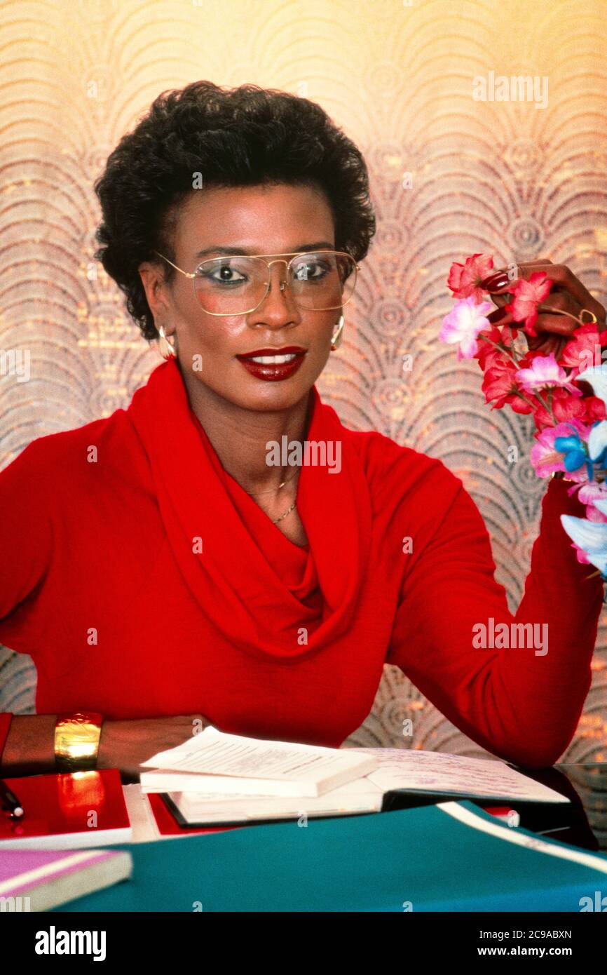 1980s AFRICAN AMERICAN BUSINESSWOMAN OR SECRETARY SITTING AT DESK