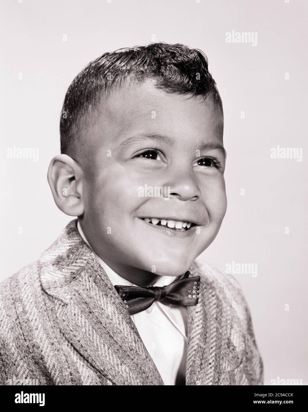 1960s PORTRAIT OF SMILING YOUNG AFRICAN-AMERICAN BOY WEARING SPORTS JACKET AND BOW TIE - n1701 HAR001 HARS AND BLACK ETHNICITY PRIDE SMILES CONNECTION JOYFUL STYLISH CHARMING COOPERATION JUVENILES PERSONABLE BLACK AND WHITE HAR001 OLD FASHIONED AFRICAN AMERICANS Stock Photo