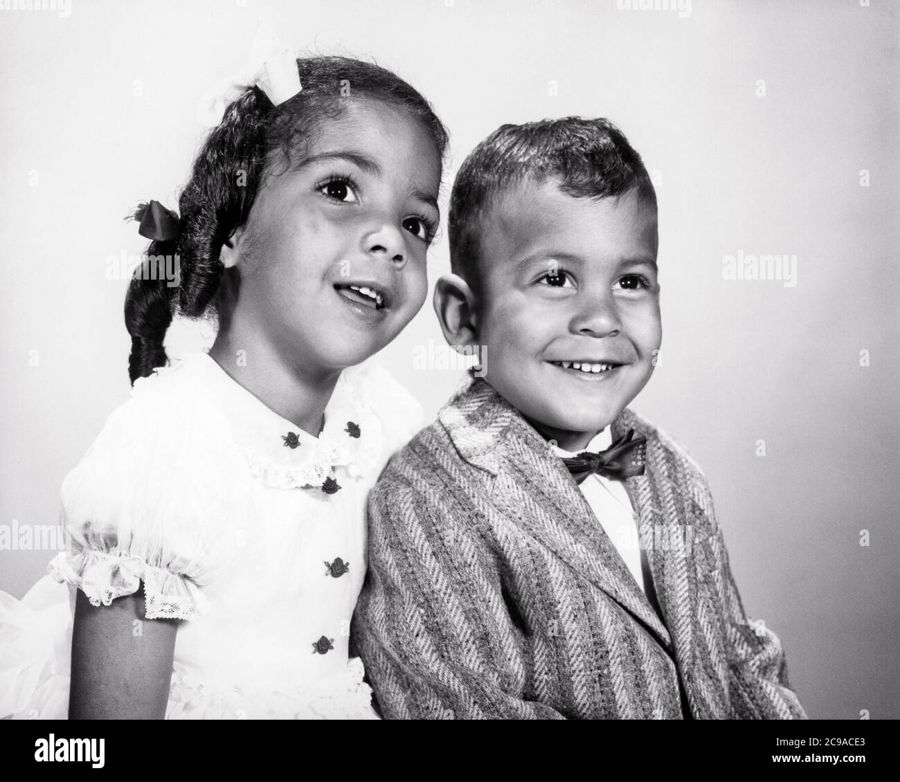 1960s PORTRAIT AFRICAN-AMERICAN BOY AND GIRL SITTING TOGETHER OLDER SISTER WHISPERING TO YOUNGER BROTHER  - n1753 HAR001 HARS STRONG JOY LIFESTYLE CELEBRATION FEMALES BROTHERS STUDIO SHOT HEALTHINESS HOME LIFE COPY SPACE FRIENDSHIP HALF-LENGTH CARING MALES SIBLINGS CONFIDENCE SISTERS EXPRESSIONS B&W HAPPINESS WELLNESS STRENGTH AFRICAN-AMERICANS AFRICAN-AMERICAN AND BLACK ETHNICITY PRIDE TO SIBLING CONNECTION STYLISH PERSONAL ATTACHMENT AFFECTION COOPERATION EMOTION GROWTH JUVENILES TOGETHERNESS YOUNGER BLACK AND WHITE HAR001 OLD FASHIONED AFRICAN AMERICANS Stock Photo
