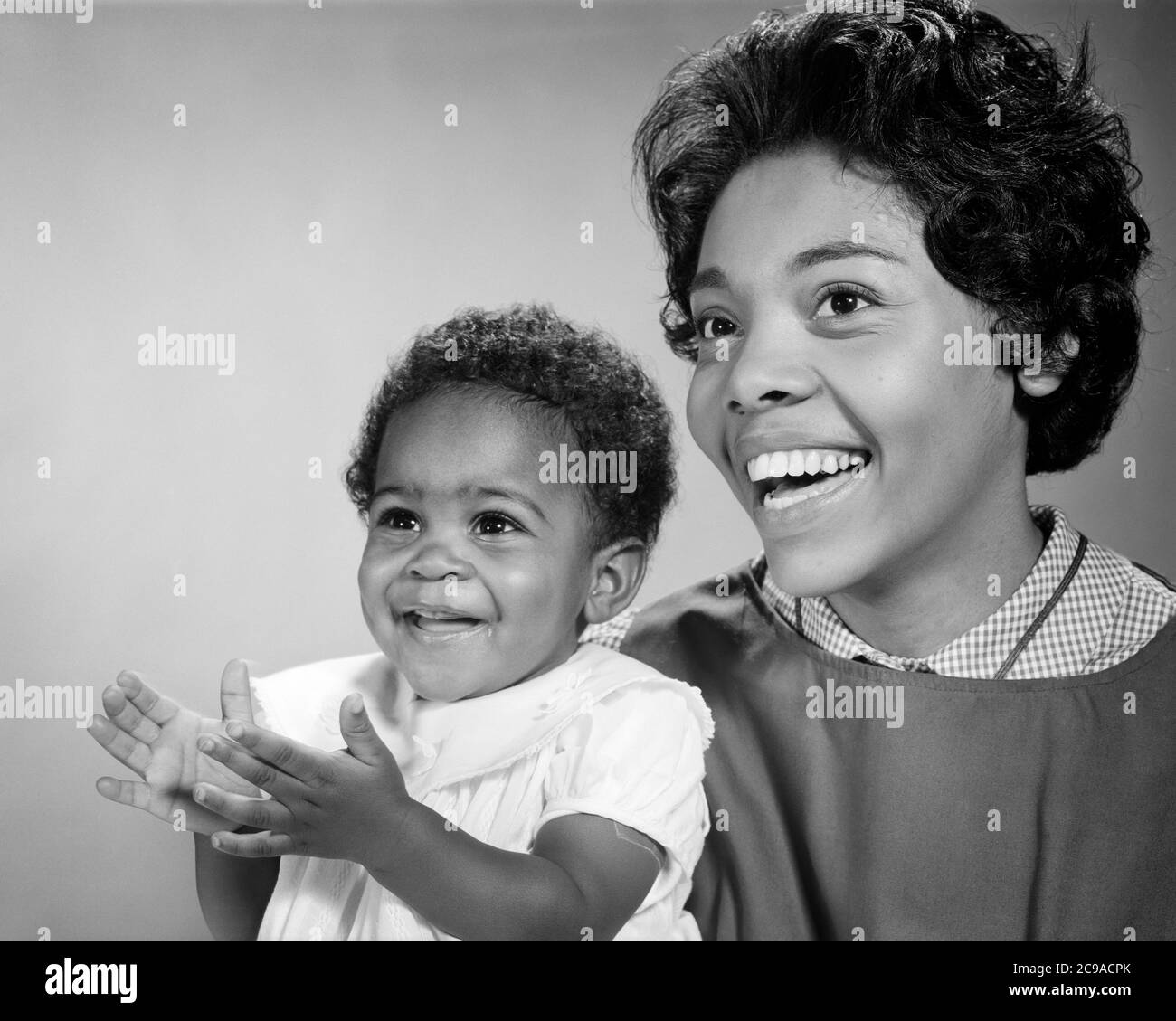1960s LAUGHING WOMAN AFRICAN-AMERICAN MOTHER LOOKING OFF CAMERA SIDE-BY-SIDE WITH HER SMILING DAUGHTER WHO IS CLAPPING HANDS - n2157 HAR001 HARS PAIR BEAUTY COMMUNITY SUBURBAN URBAN HER MOTHERS EXPRESSION OLD TIME NOSTALGIA OLD FASHION 1 JUVENILE FACIAL COMMUNICATION LAUGH YOUNG ADULT TEAMWORK PLEASED JOY LIFESTYLE SATISFACTION CELEBRATION FEMALES CLAPPING HEALTHINESS HOME LIFE COPY SPACE LADIES DAUGHTERS PERSONS CARING SERENITY SPIRITUALITY CONFIDENCE EXPRESSIONS B&W DREAMS HAPPINESS HEAD AND SHOULDERS CHEERFUL PROTECTION AFRICAN-AMERICANS AFRICAN-AMERICAN EXCITEMENT BLACK ETHNICITY PRIDE Stock Photo