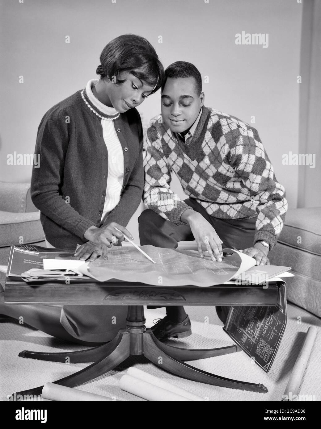 1960s AFRICAN-AMERICAN COUPLE MAN WOMAN HUSBAND AND WIFE HEADS TOGETHER GOING OVER PLANS BLUEPRINTS FOR NEW HOME - n2248 HAR001 HARS STRONG JOY LIFESTYLE SATISFACTION ARCHITECTURE FEMALES HOUSES MARRIED HEADS STUDIO SHOT SPOUSE HUSBANDS HEALTHINESS HOME LIFE PLANS COPY SPACE FRIENDSHIP HALF-LENGTH LADIES PERSONS INSPIRATION RESIDENTIAL CARING MALES PLANNING BUILDINGS CONFIDENCE BLUEPRINTS B&W PARTNER GOALS DREAMS HAPPINESS PROPERTY AFRICAN-AMERICANS AFRICAN-AMERICAN PROGRESS BLACK ETHNICITY PRIDE OPPORTUNITY HOMES REAL ESTATE CONNECTION CONCEPTUAL STRUCTURES RESIDENCE STYLISH EDIFICE Stock Photo