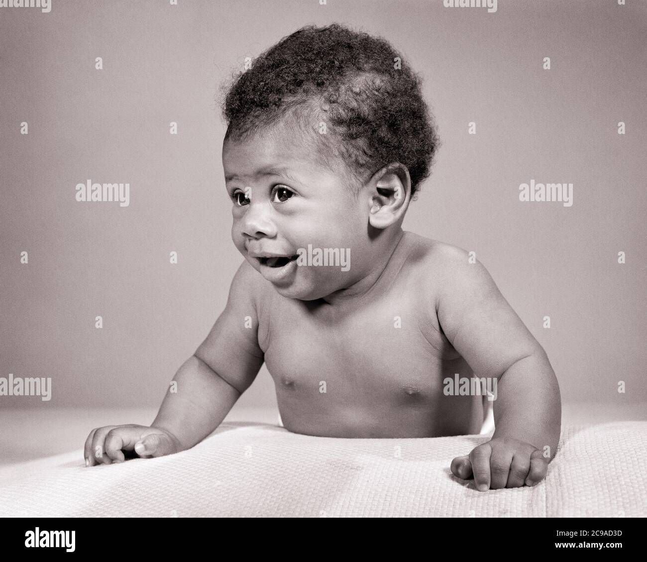 1960s SMILING BRIGHT-EYED AFRICAN-AMERICAN BABY BOY PUSHING UP READY TO CRAWL  - n2298 HAR001 HARS ATHLETICS COPY SPACE HALF-LENGTH MALES ATHLETIC CONFIDENCE B&W ACTIVITY HAPPINESS PHYSICAL HEAD AND SHOULDERS CHEERFUL CRAWL STRENGTH AFRICAN-AMERICAN PRIDE TO UP SMILES CONCEPTUAL ATHLETES FLEXIBILITY JOYFUL MUSCLES BABY BOY GROWTH JUVENILES BLACK AND WHITE HAR001 OLD FASHIONED Stock Photo