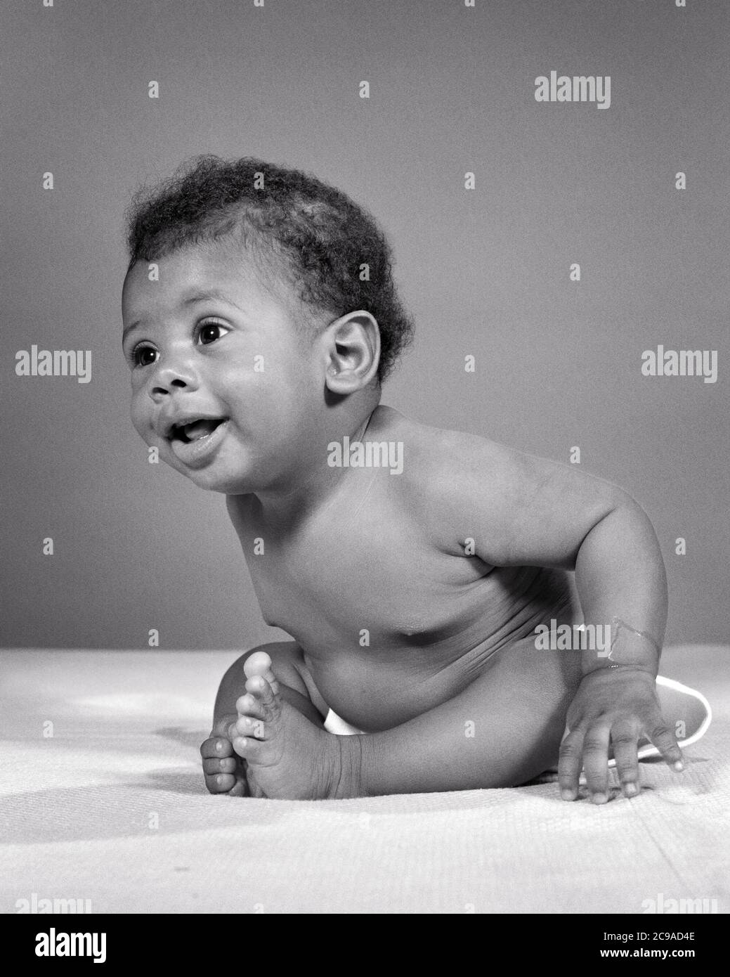1960s ENERGETIC YOUNG AFRICAN-AMERICAN BABY BOY SITTING UP LEANING FORWARD WIDE-EYED AND CURIOUS - n2309 HAR001 HARS ADVENTURE DISCOVERY STRENGTH AFRICAN-AMERICANS AFRICAN-AMERICAN AND EXCITEMENT BLACK ETHNICITY UP CONCEPTUAL CURIOUS STYLISH BABY BOY WIDE-EYED ENERGETIC GROWTH JUVENILES BLACK AND WHITE HAR001 INQUISITIVE OLD FASHIONED AFRICAN AMERICANS Stock Photo
