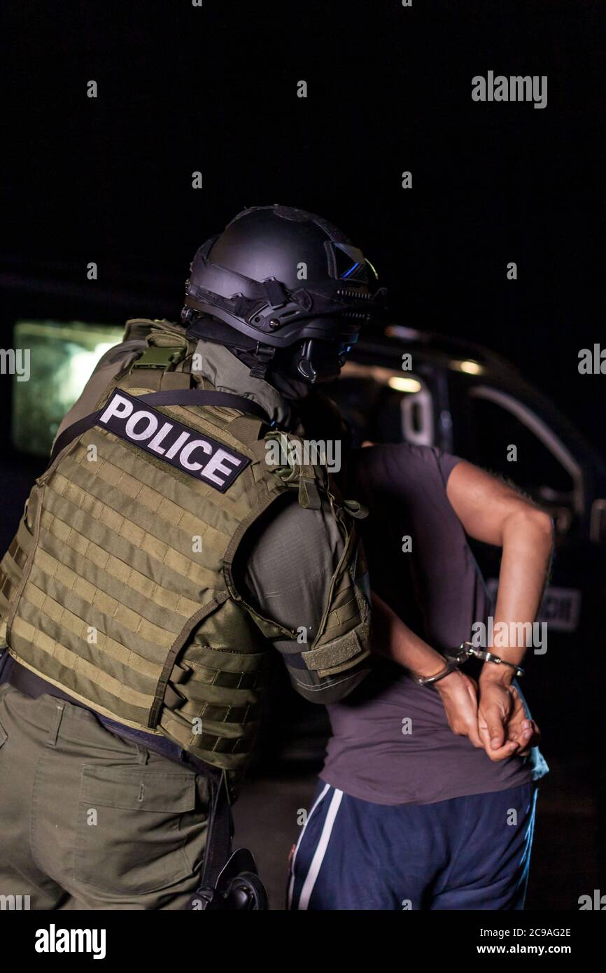 A police officer puts handcuffs on a criminal's hands during an arrest