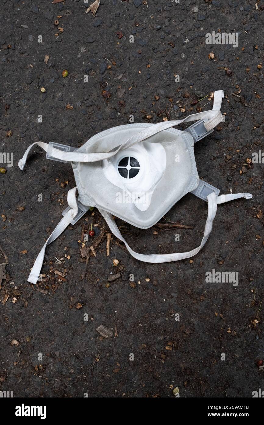Face mask with valve discarded and dropped on road during coronavirus pandemic, Scotland, UK Stock Photo