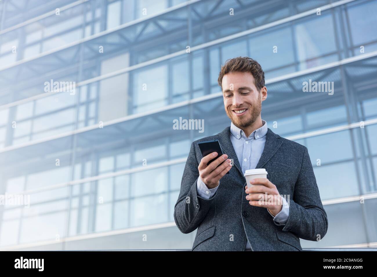 Businessman holding mobile phone using app texting Stock Photo