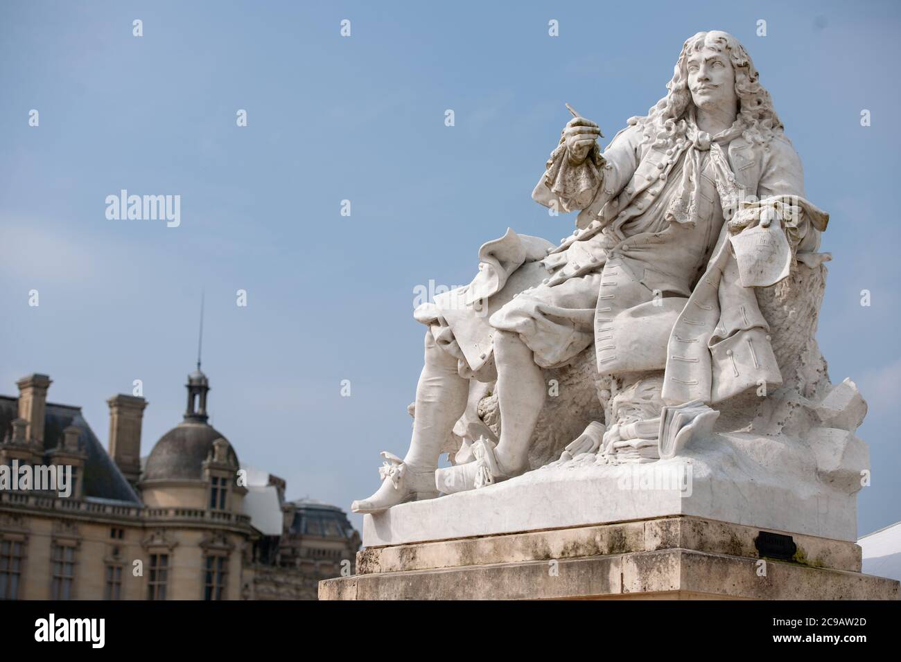 Statue of the playwright Molière by the sculptor Tony Noël at Château de Chantilly with the chateau in the background Stock Photo