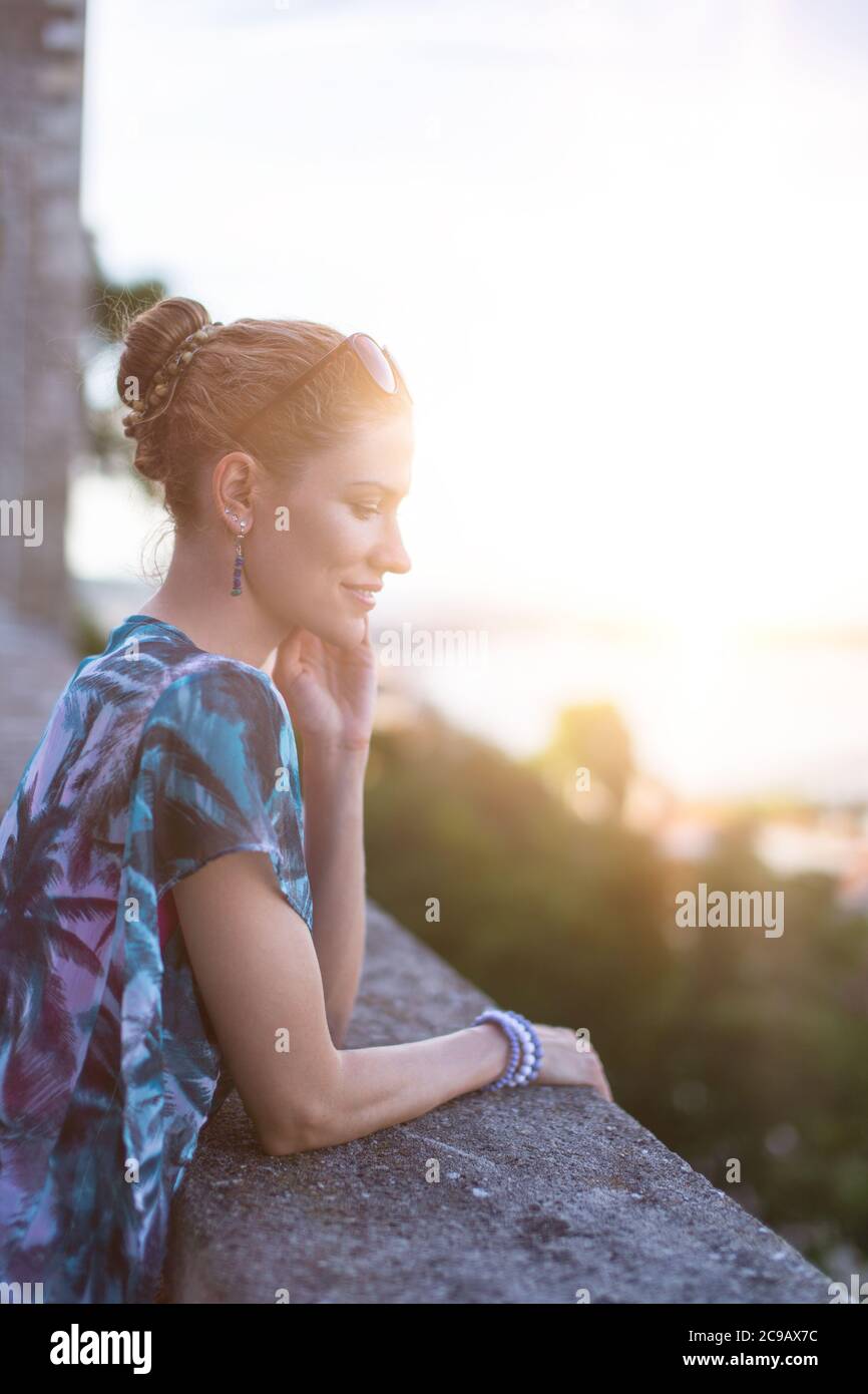 Young adult woman daydreaming about love in sunset Stock Photo