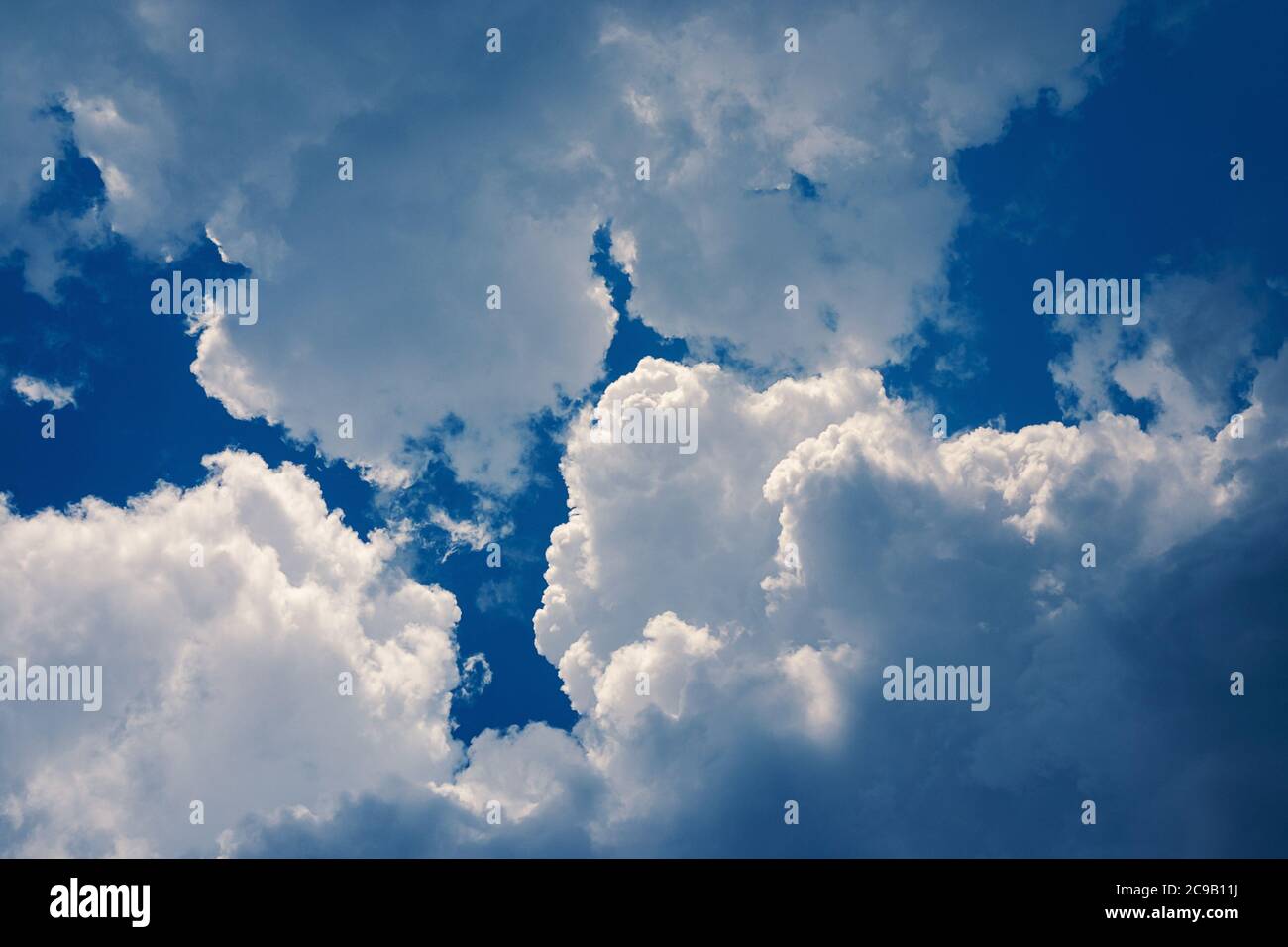 cumulus clouds high up in blue sky over head Stock Photo