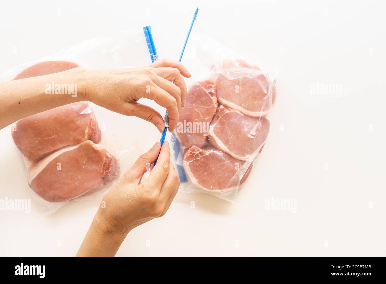 https://c8.alamy.com/comp/2C9B7MB/raw-boneless-pork-loin-chops-in-zip-lock-bags-woman-packs-meat-in-bags-close-up-view-white-background-directly-from-above-2C9B7MB.jpg