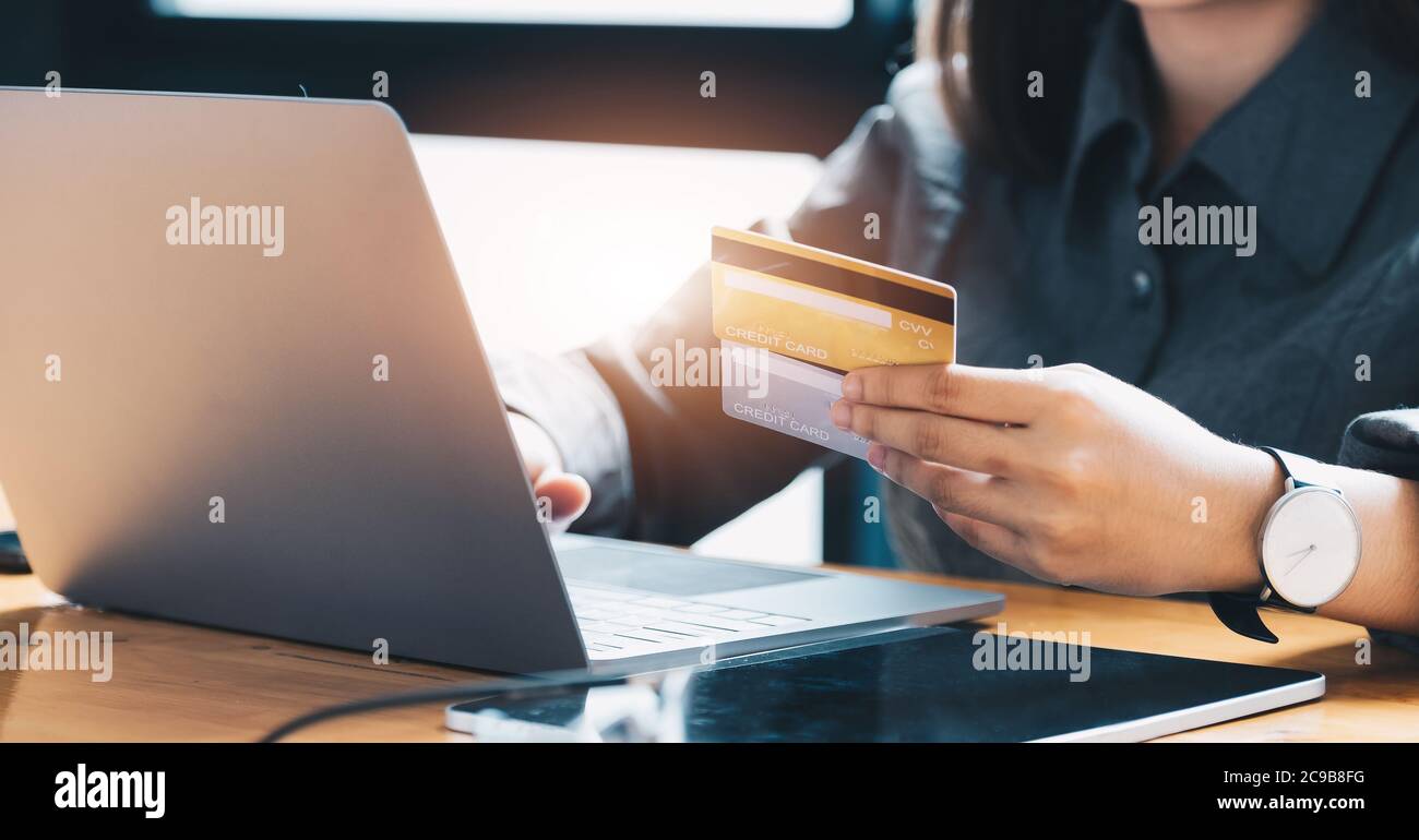 Young woman holding credit card and using laptop computer. Online shopping concept Stock Photo