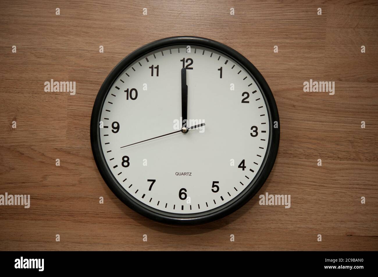 wall clock indicating the twelve o'clock hour Stock Photo Alamy