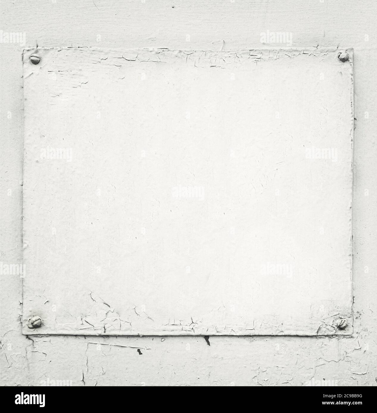 old grungy white painted plaque on wall Stock Photo