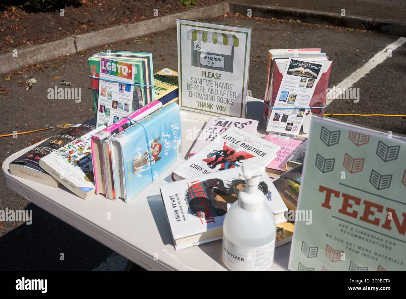 Signs at Lake Oswego's outdoor library remind readers to sanitize hands before and after browsing books to prevent the spread of the coronavirus. Stock Photo