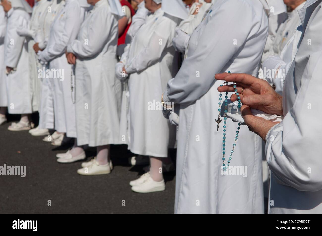 Close up of mans hands holding rosary beads and cross while praying, Ireland Stock Photo