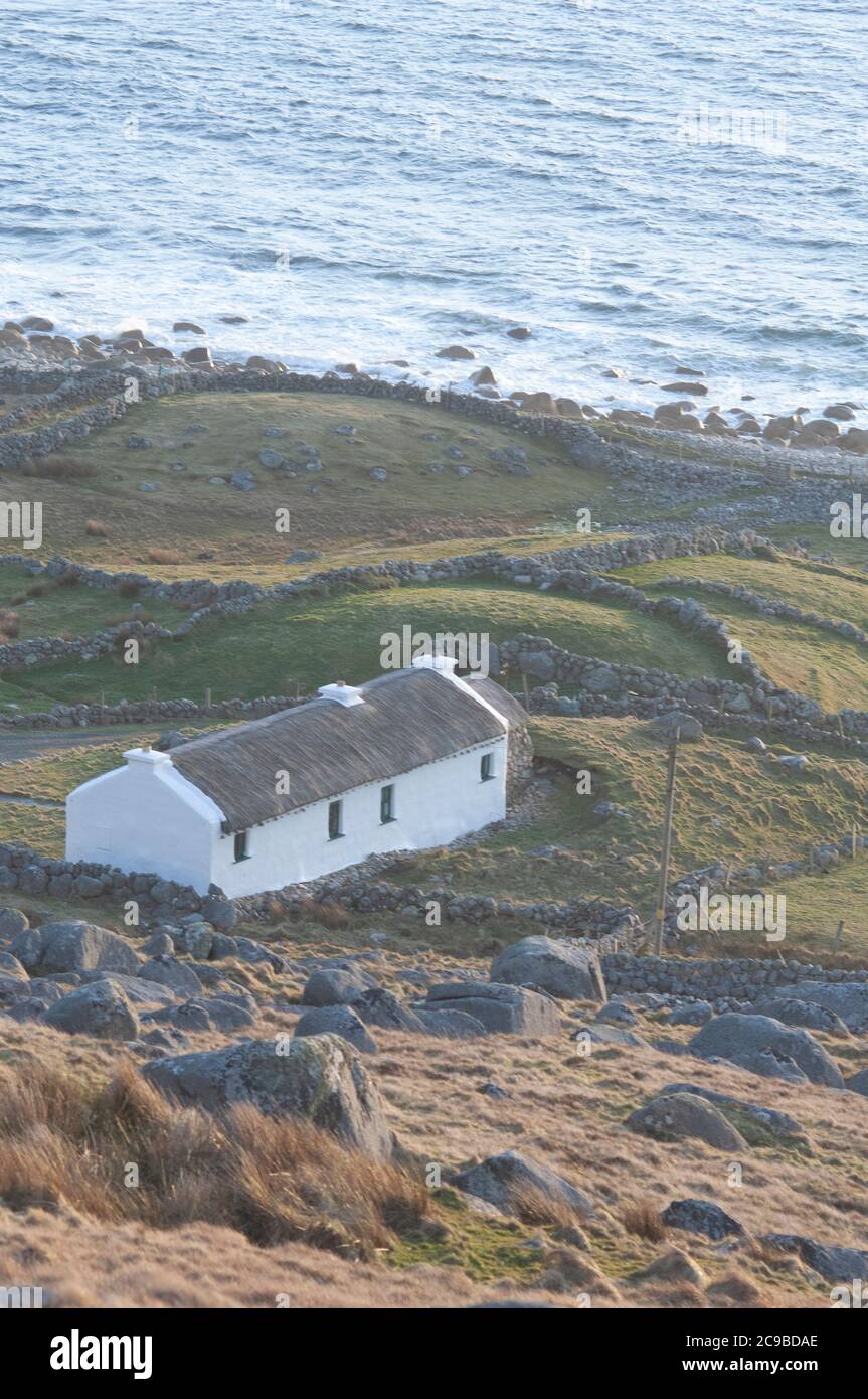 Irish cottage with thatched roof by the ocean in the west of Ireland, Ireland Stock Photo