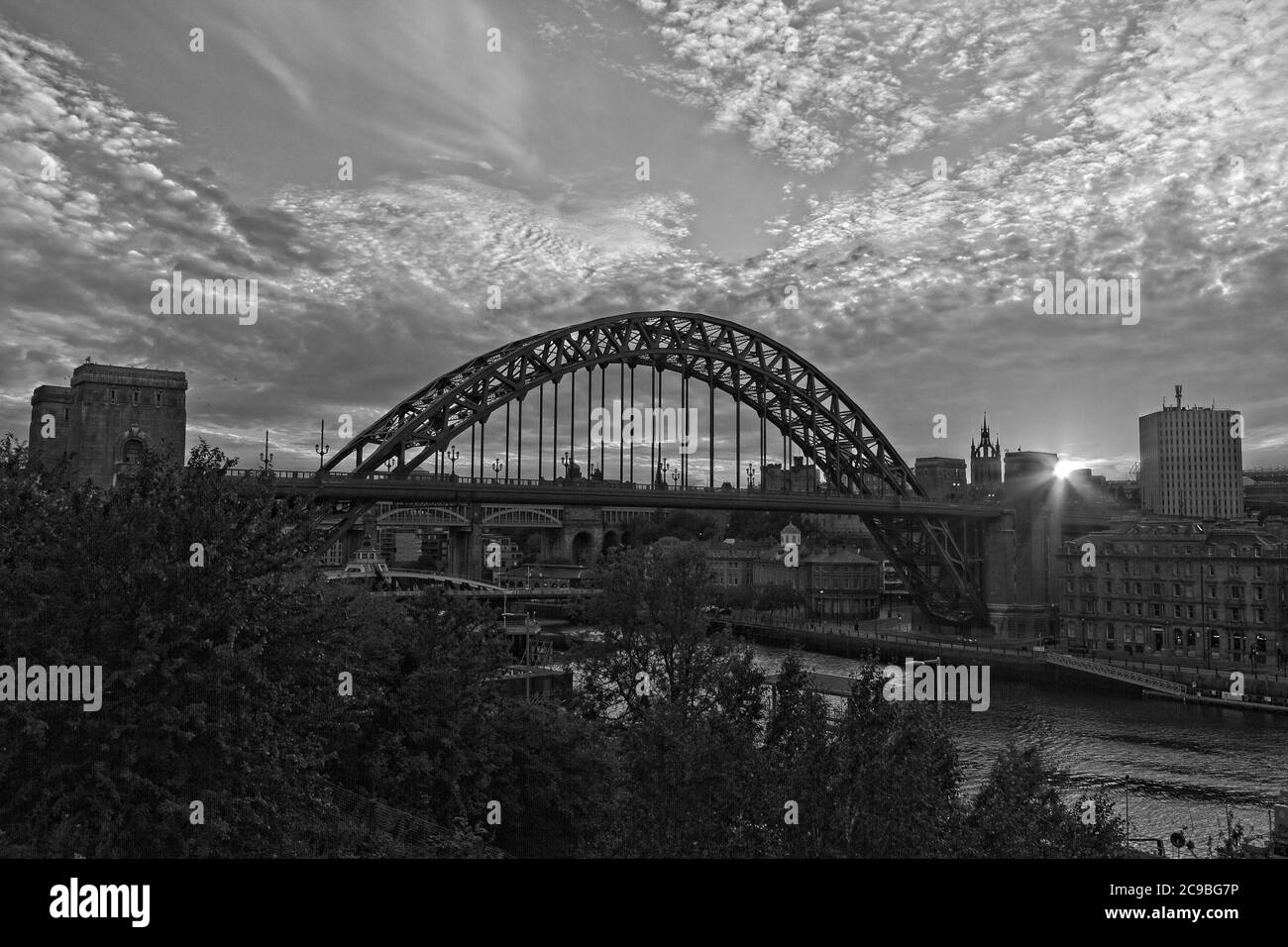 The iconic arch of the Tyne Bridge and quayside in Newcastle, Tyne and Wear taken at sunset from the Gateshead side of the River Tyne. Stock Photo