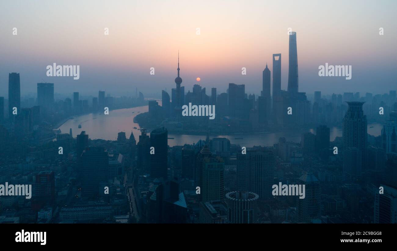 Sun rising above the Shanghai skyline. With skyscrapers and Huangpu River. Stock Photo