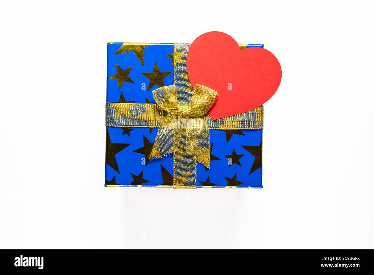 Gift or present box with golden ribbon and paper heart on white background top view. Stock Photo