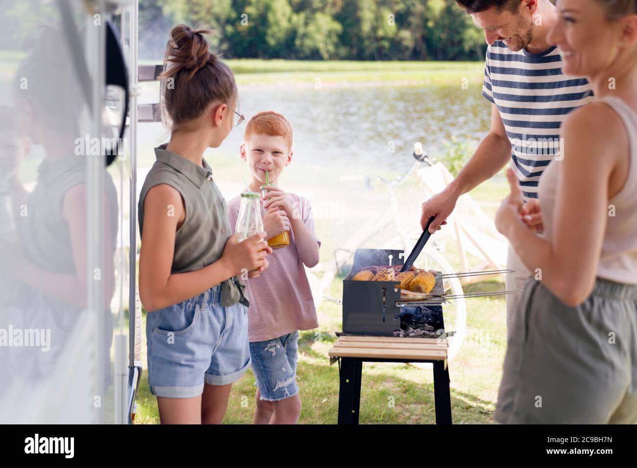 Family having barbecue during camper trip Stock Photo
