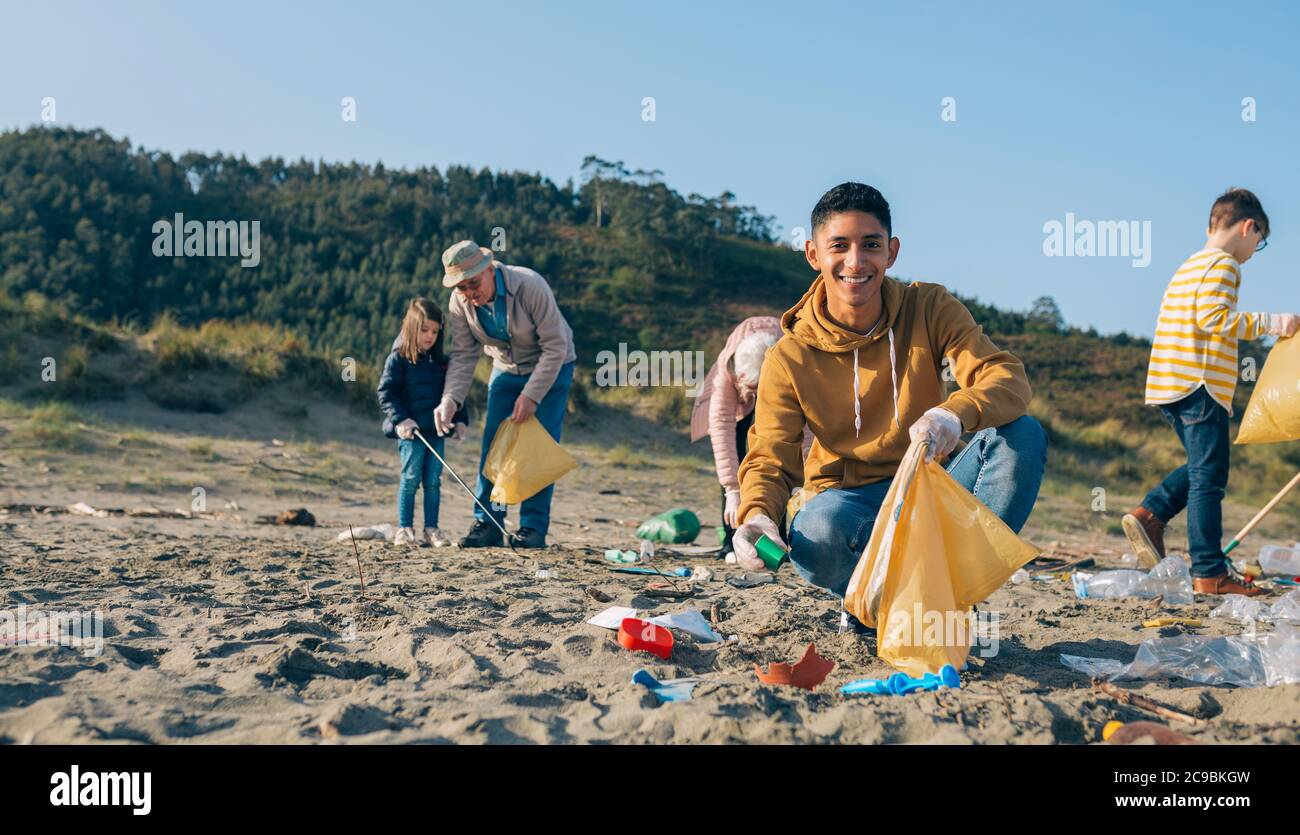 Young man cleaning the beach Stock Photo