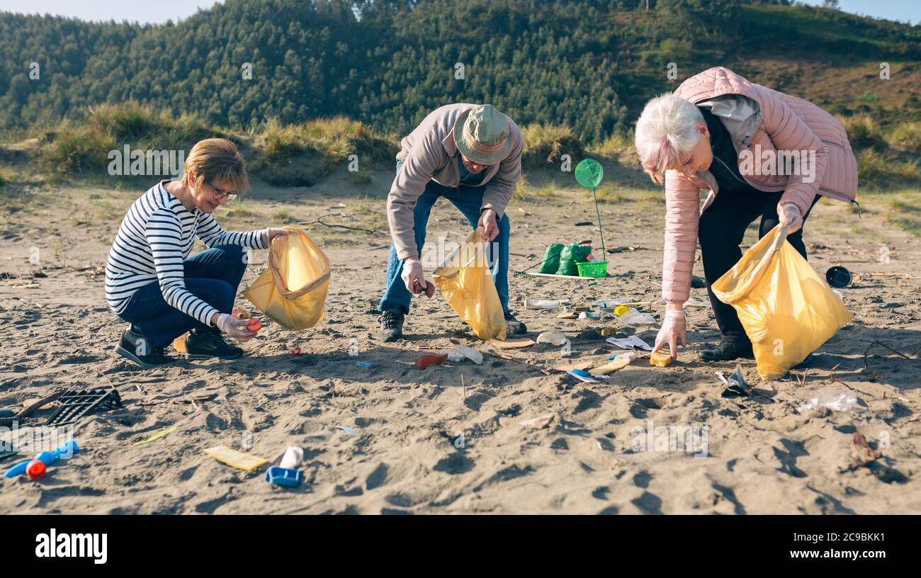 Senior volunteers cleaning the beach Stock Photo