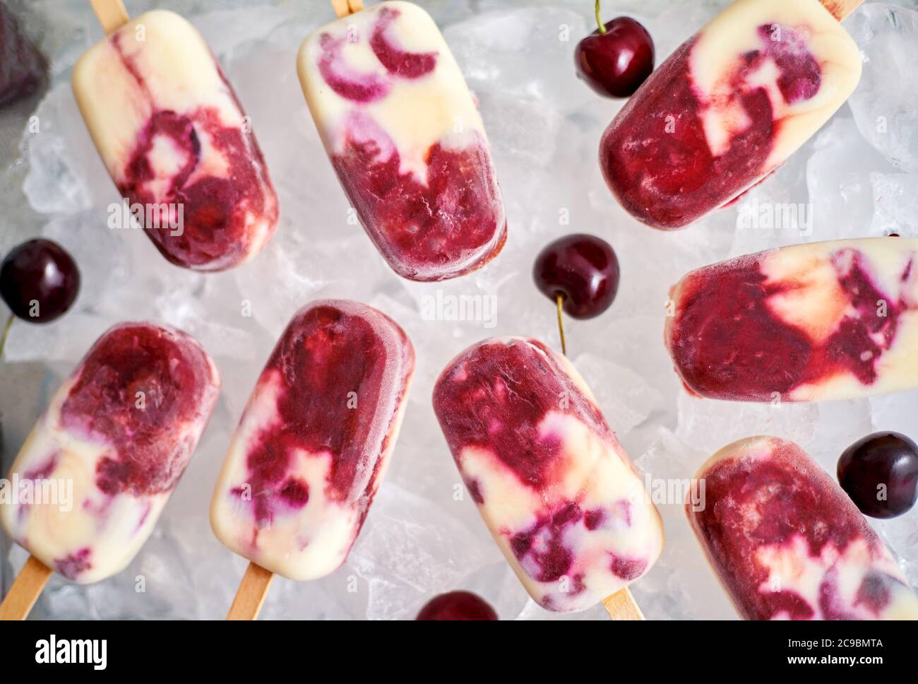 Homemade, delicious, cherry and milk ice cream popsicles placed on