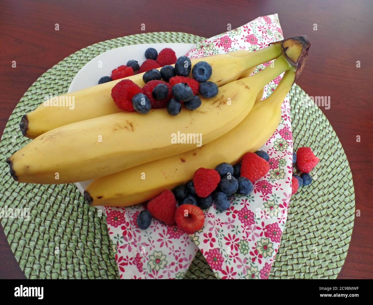 Bananas with raspberries and blueberries Stock Photo