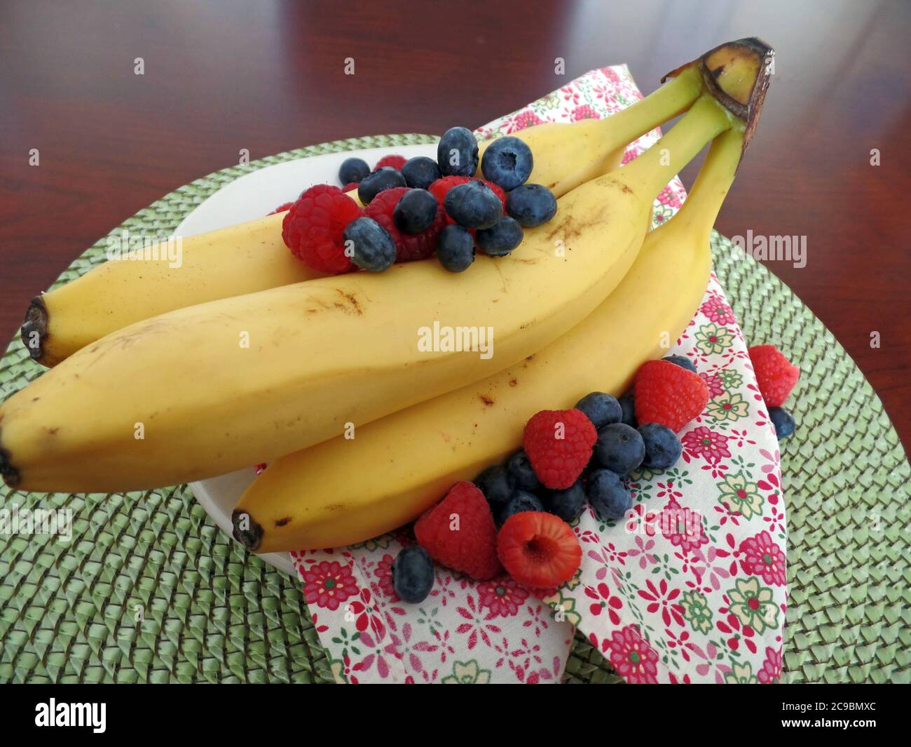 Bananas with raspberries and blueberries Stock Photo