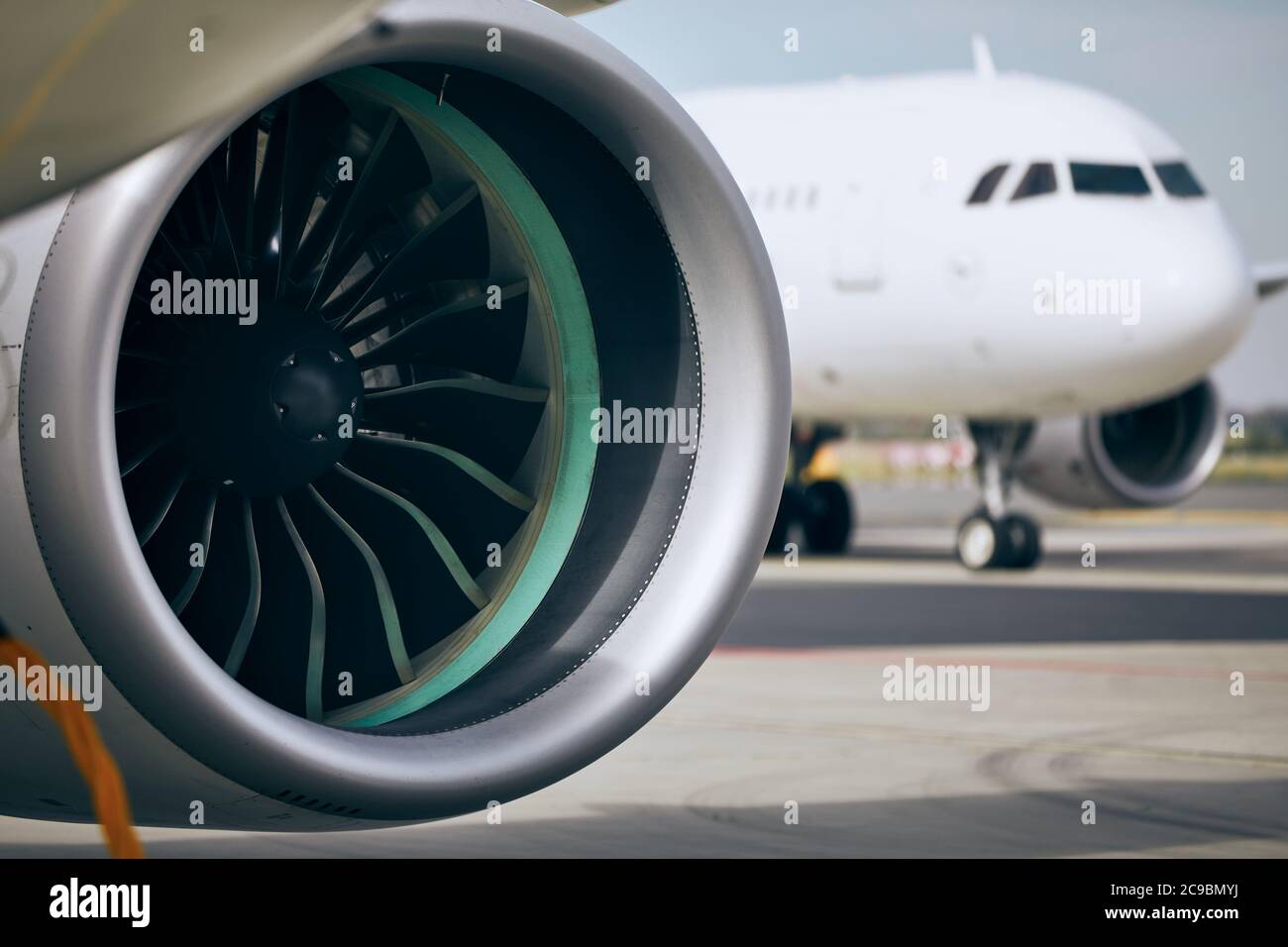 Jet engine of commercial airplane against traffic at airport. Stock Photo
