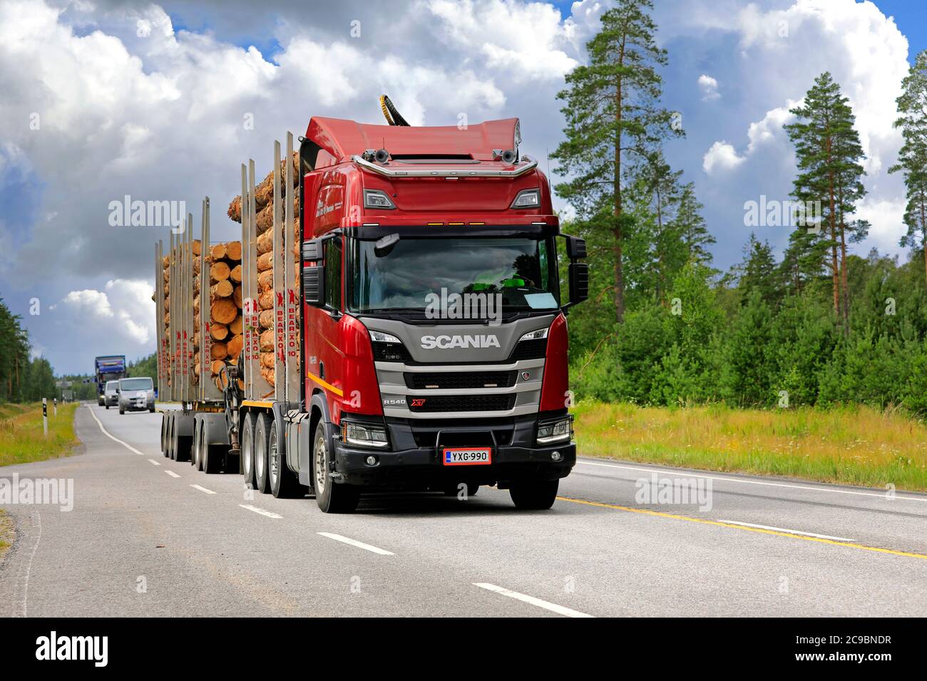Red Scania R540 XT logging truck of Kuljetus Simo Iitti Ky pulls pine log load along highway 25 in the summer. Raasepori, Finland. July 24, 2020. Stock Photo
