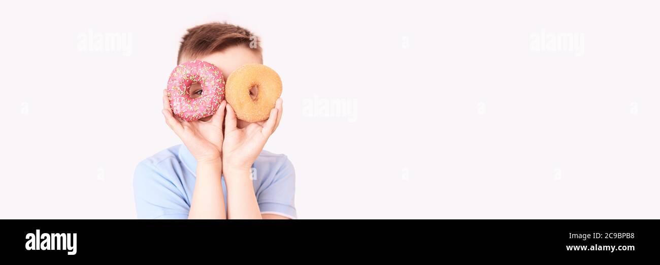 A boy with two doughnut. A place for text. Modern concept without a face Stock Photo