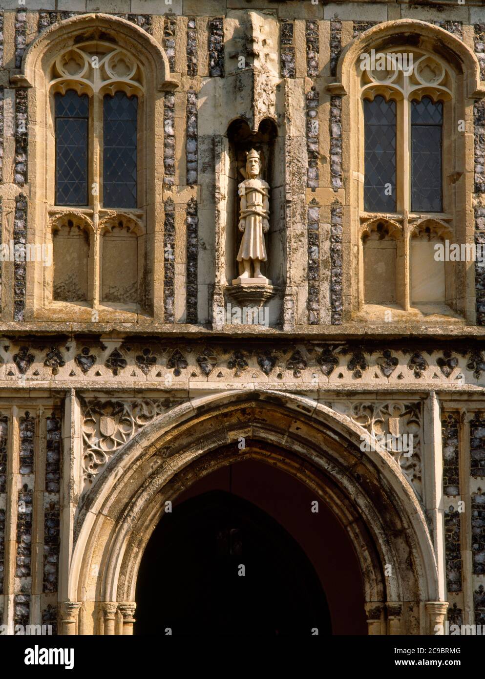 A modern (1989) statue of St Edmund in a canopied niche on the C15th Perpendicular two-storey S porch of his church at Southwold, Suffolk, England, UK Stock Photo