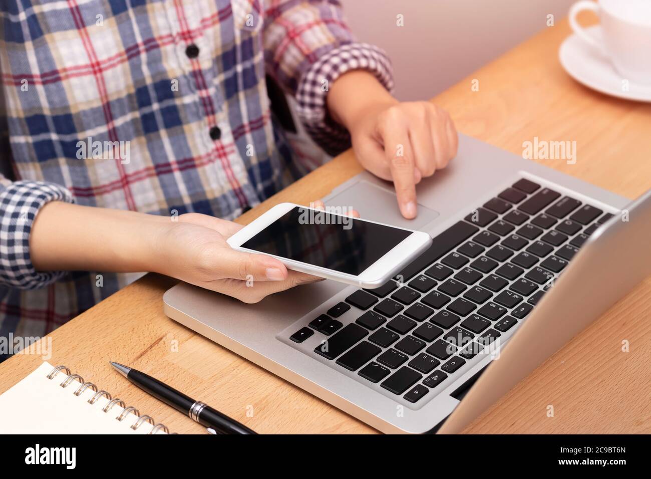people working from home using smart phone and notebook laptop computer at workplace, anonymous face. internet marketing concept Stock Photo