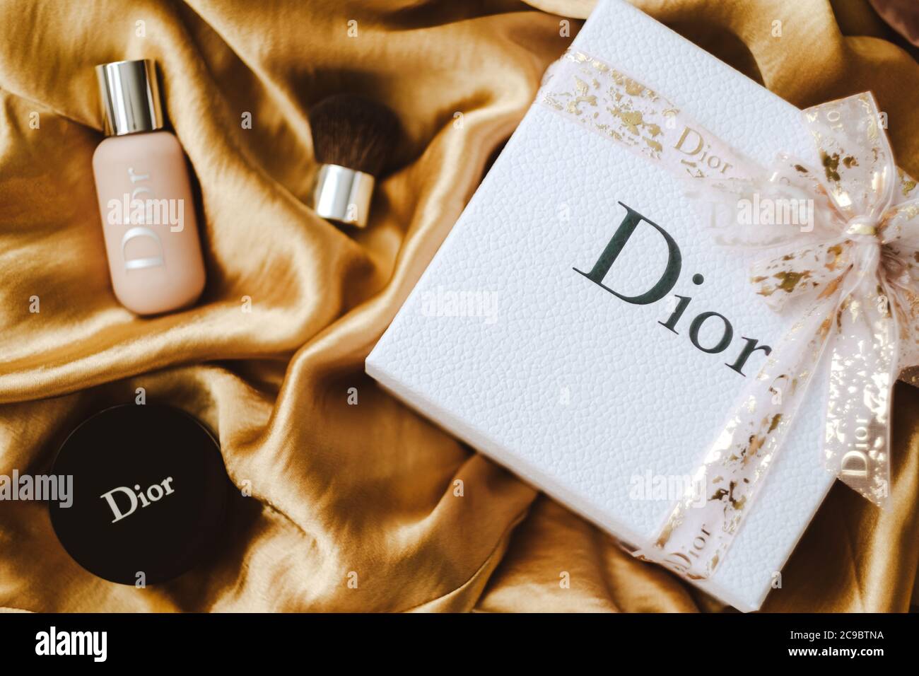 Gift box from DIOR with makeup on a golden fabric Stock Photo Alamy