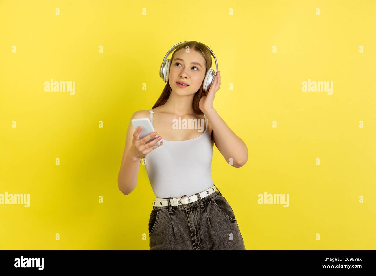 Listening to music with headphones. Caucasian young girl's portrait on ...