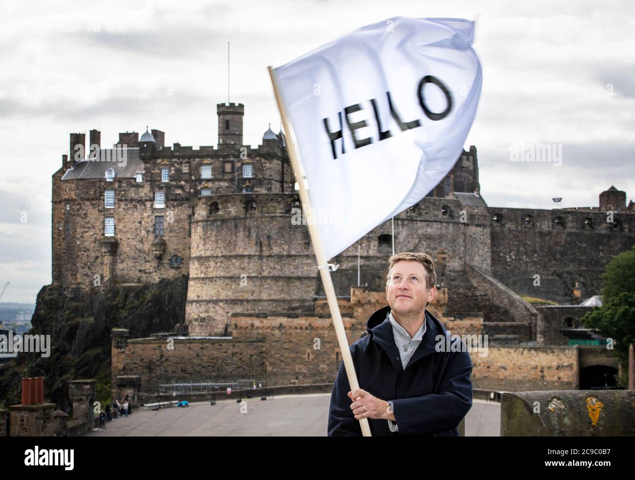 Artist Peter Liversidge flies one of his HELLO flags above the rooftops of Edinburgh as he revisits his 2013 Edinburgh Art Festival commission Flags for Edinburgh which invited buildings across the city to fly a white flag that reads HELLO. Stock Photo