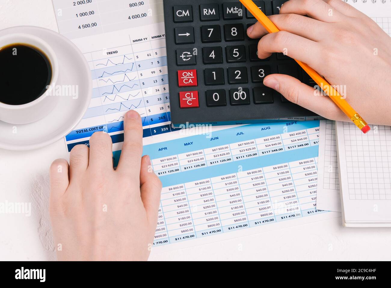 Businessman works with documents. Financial documents with charts, figures, and money. Calculator and hands. Marketing research, financial analysis of Stock Photo